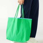 woman holding le canvas tote in green