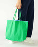woman holding le canvas tote in green