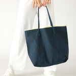 woman holding le canvas tote in navy