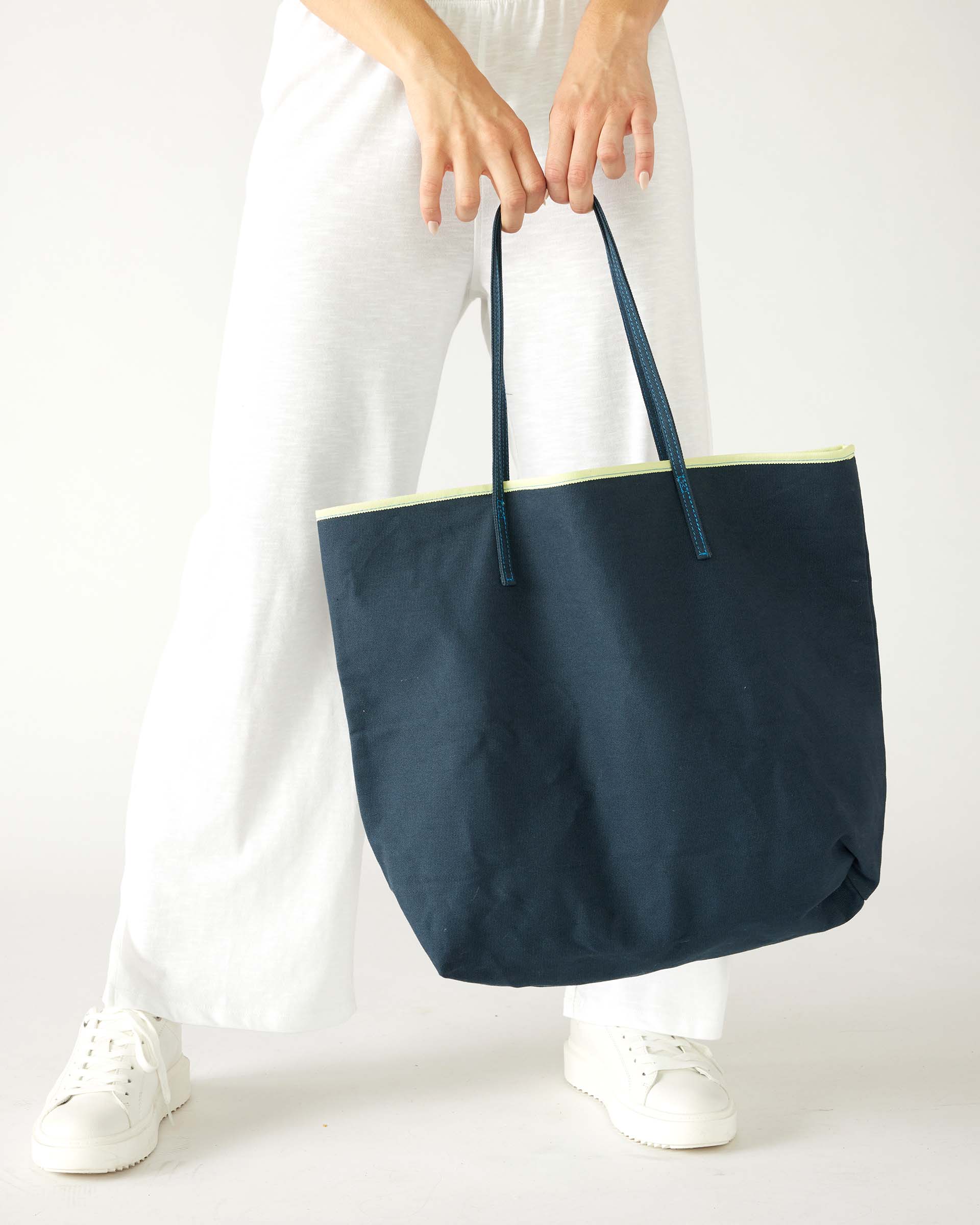 woman holding le canvas tote in navy