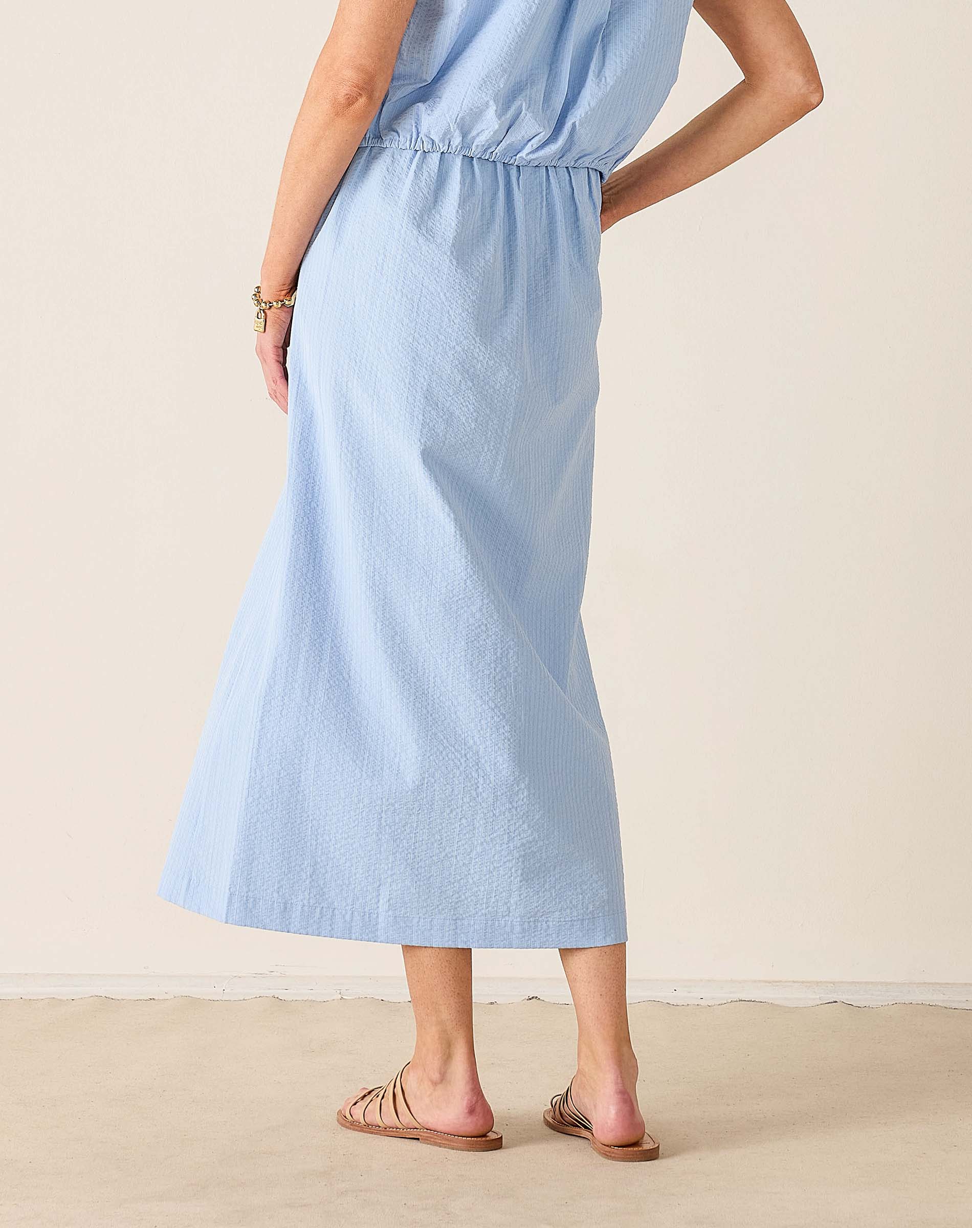 Light blue dress worn by a person on a beige background
