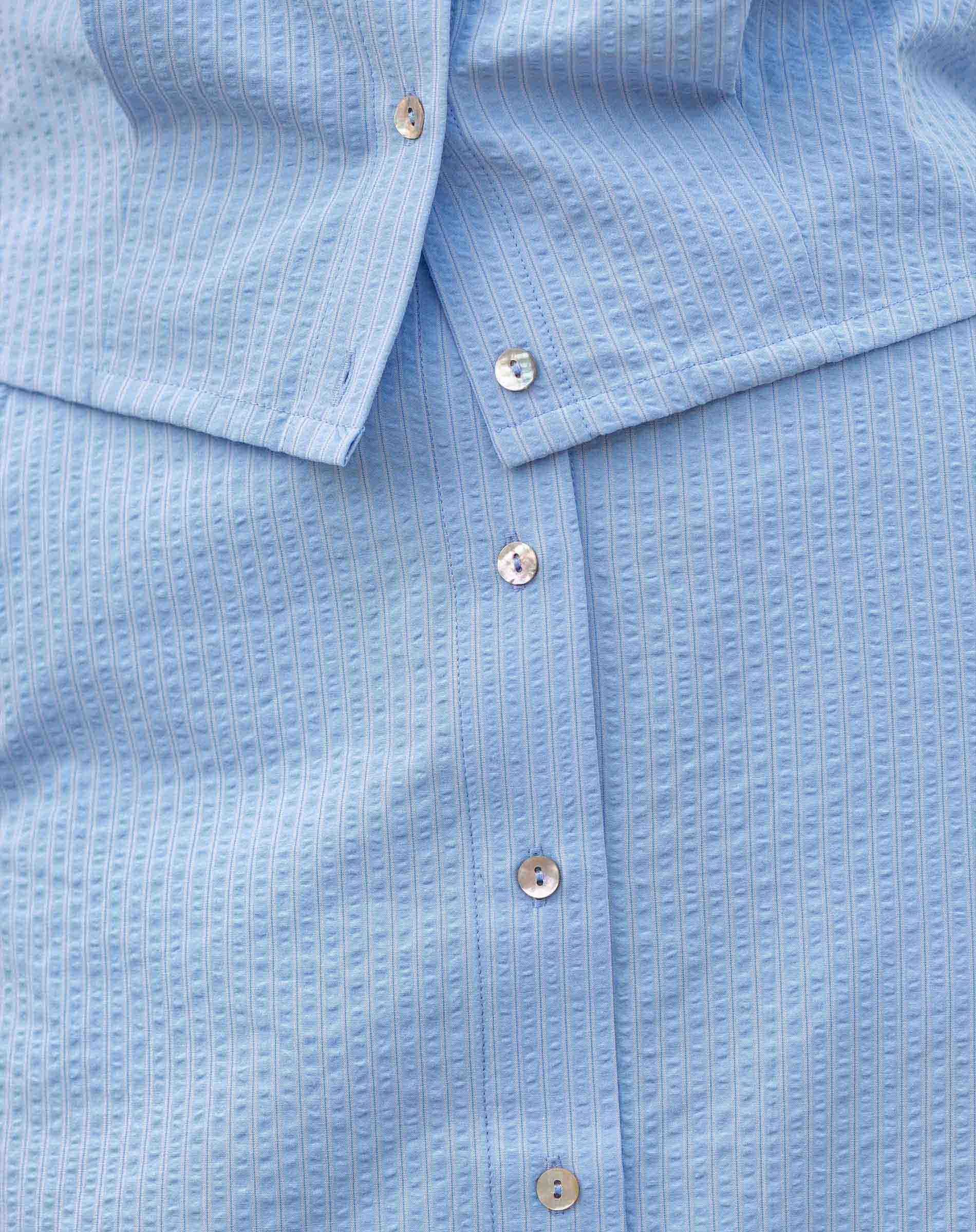 Close-up of a blue textured shirt with buttons