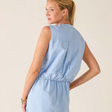 Woman wearing a light blue dress against a plain background