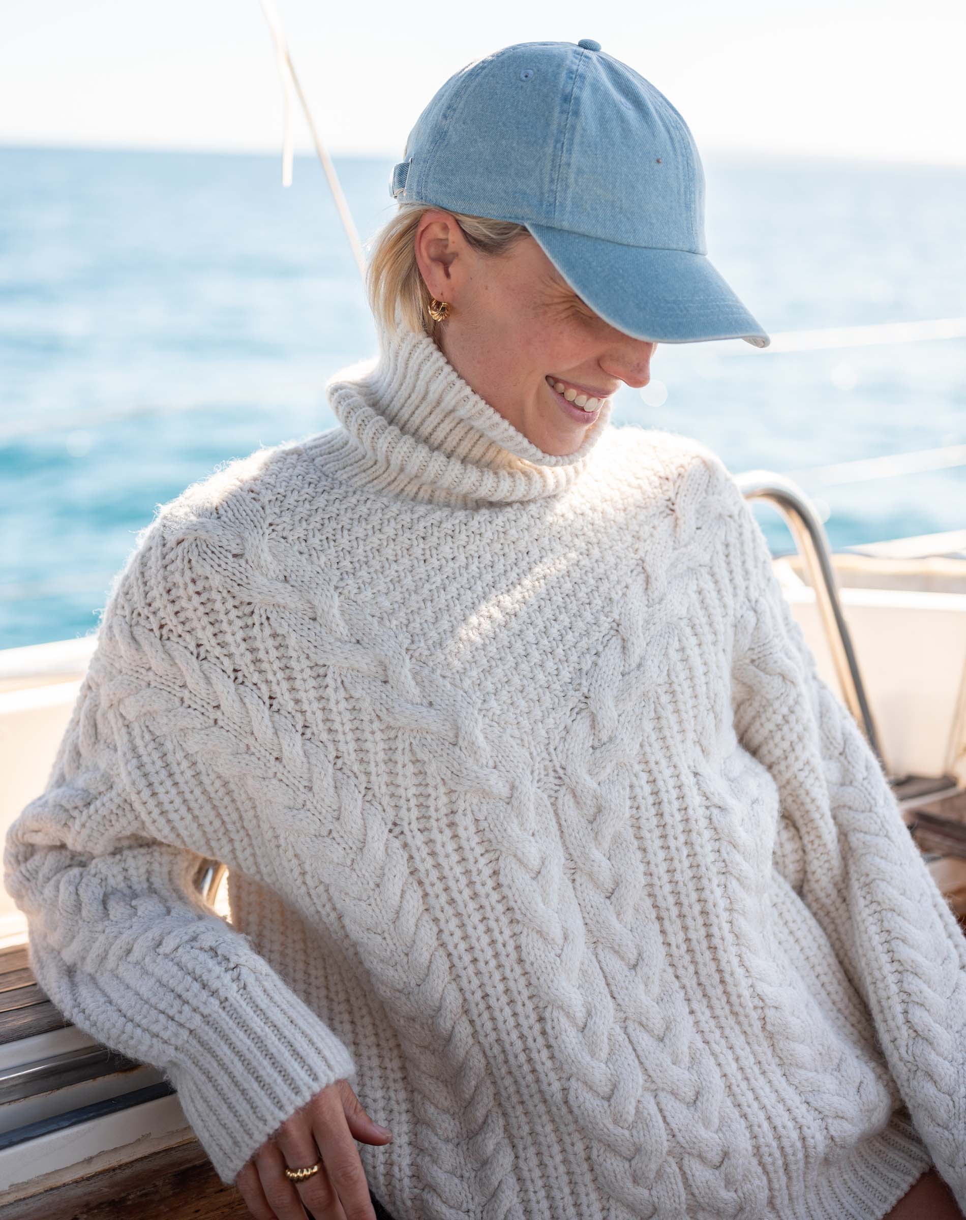 Cream cable-knit turtleneck sweater with a chunky knit design.