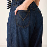 Person wearing blue denim pants with a white background