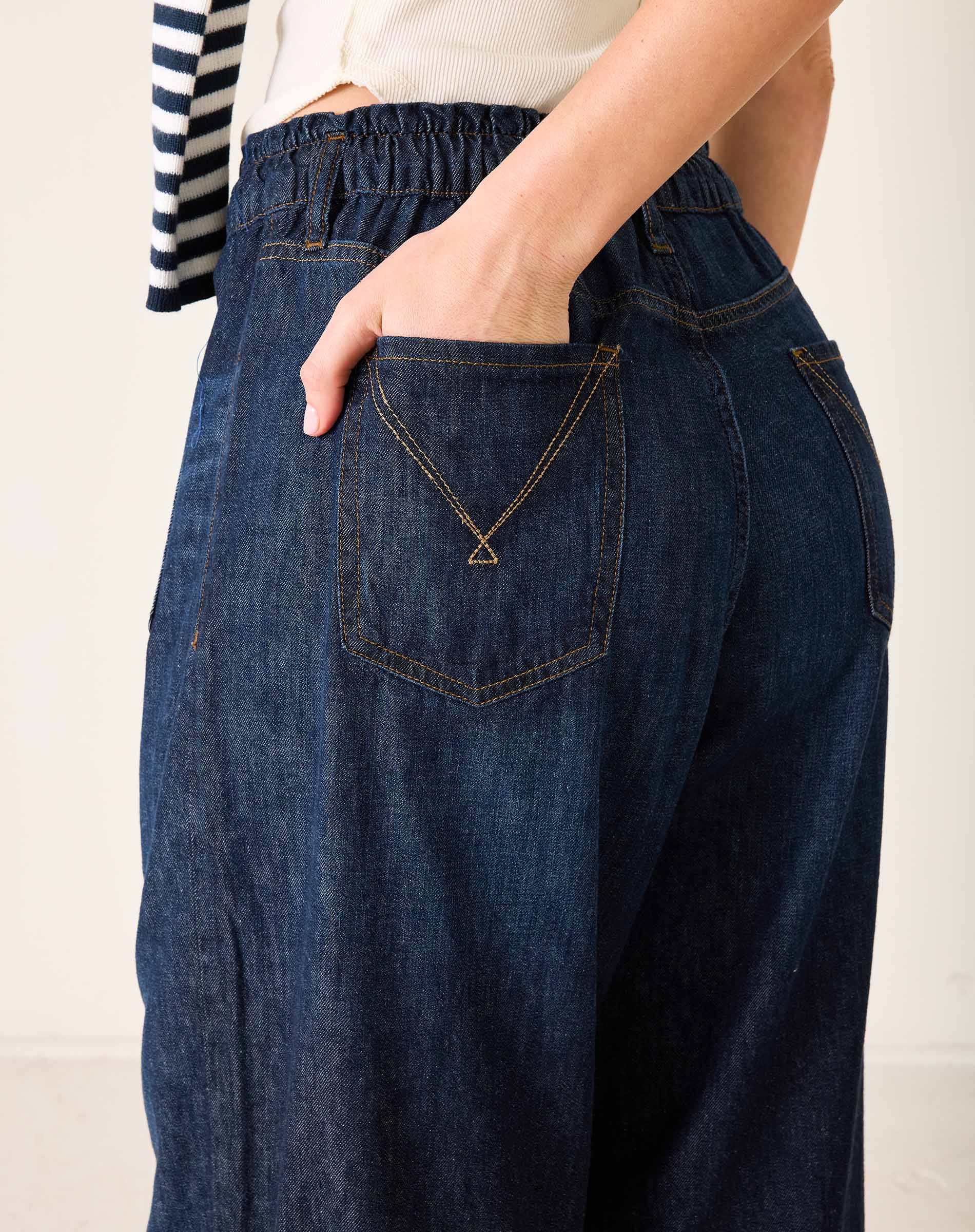 Person wearing blue denim pants with a white background