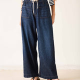 Person wearing wide-leg jeans and a striped shirt on a plain background