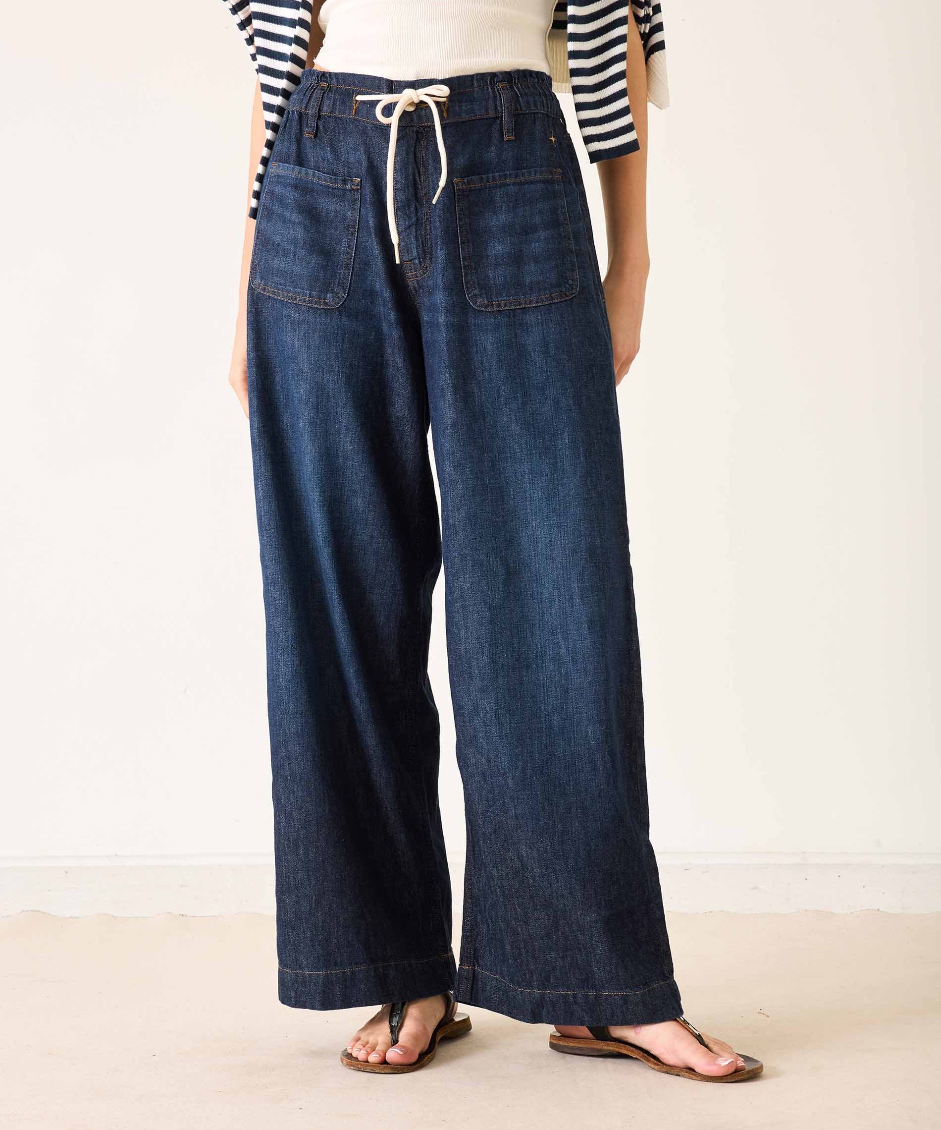 Person wearing wide-leg jeans and a striped shirt on a plain background