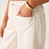 Person wearing white pants with a neutral background