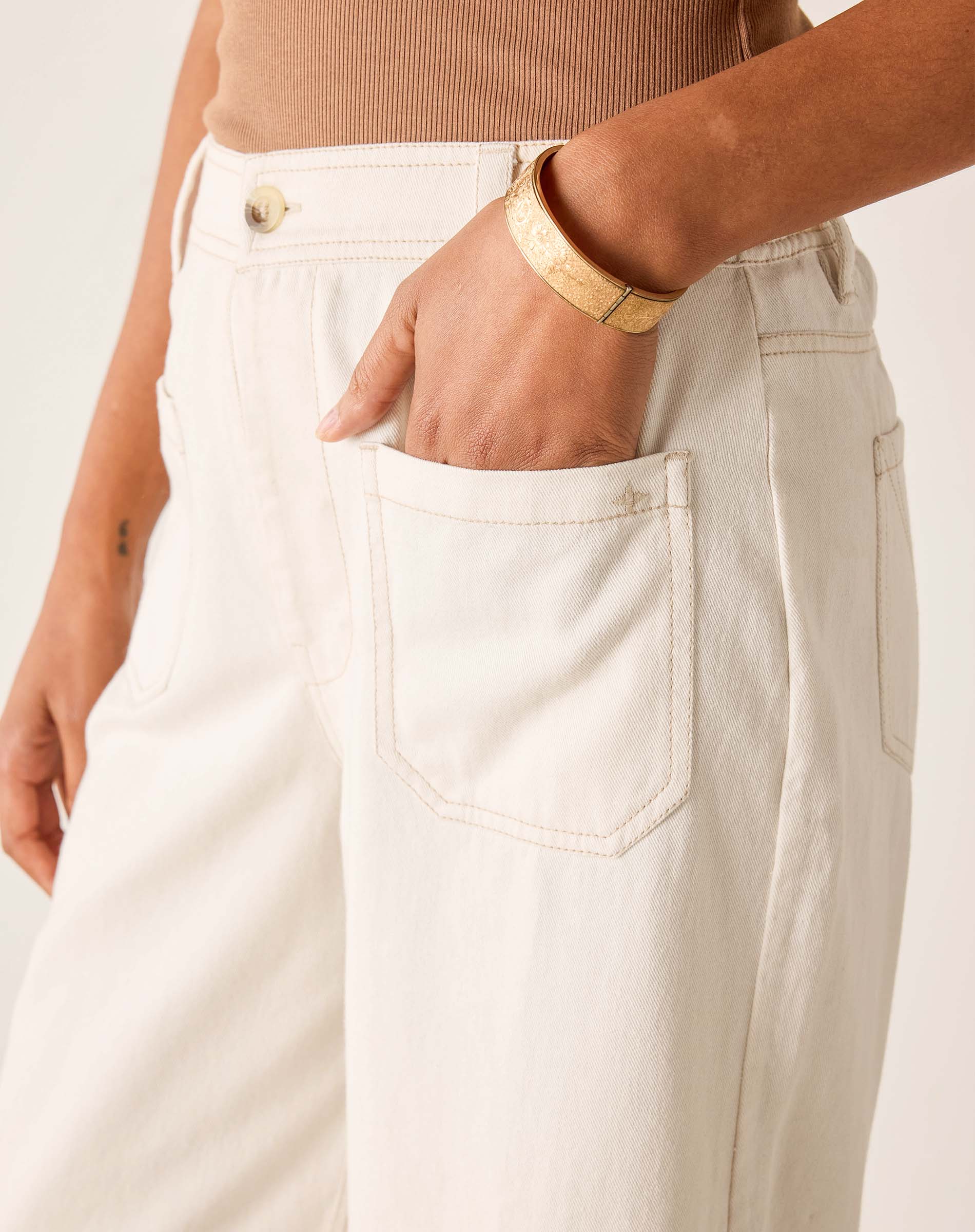 Person wearing white pants with a neutral background