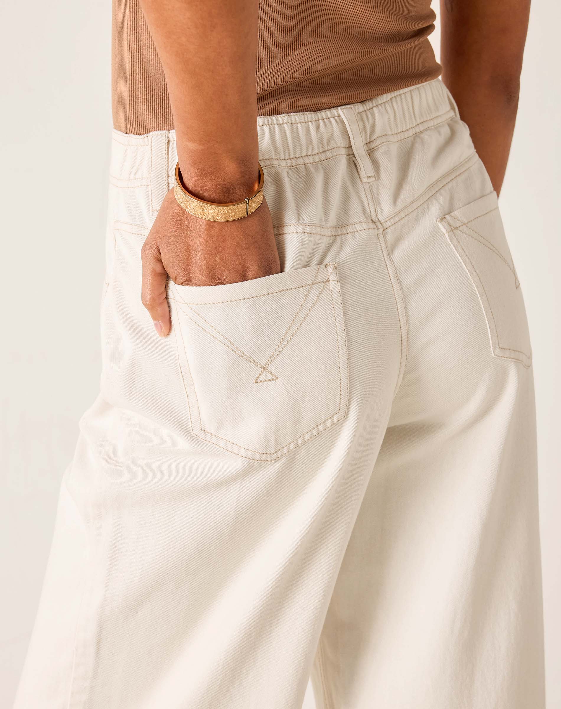 Person wearing beige pants with a neutral background