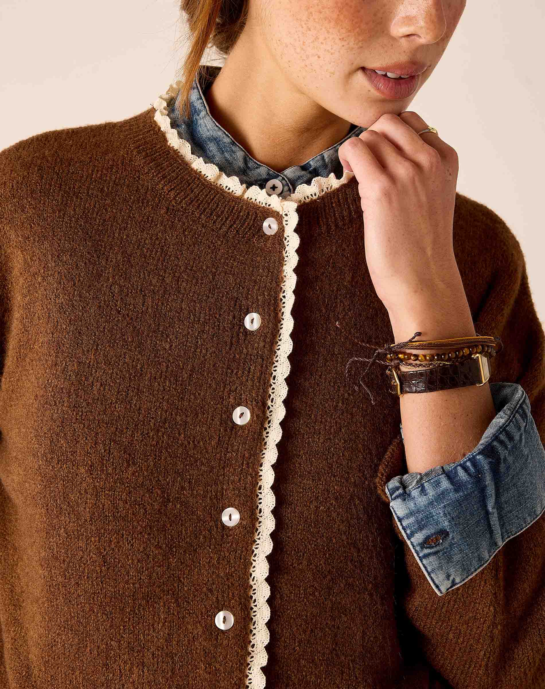 Cocoa brown knit sweater featuring a white lace trim along the buttoned front and neckline.
