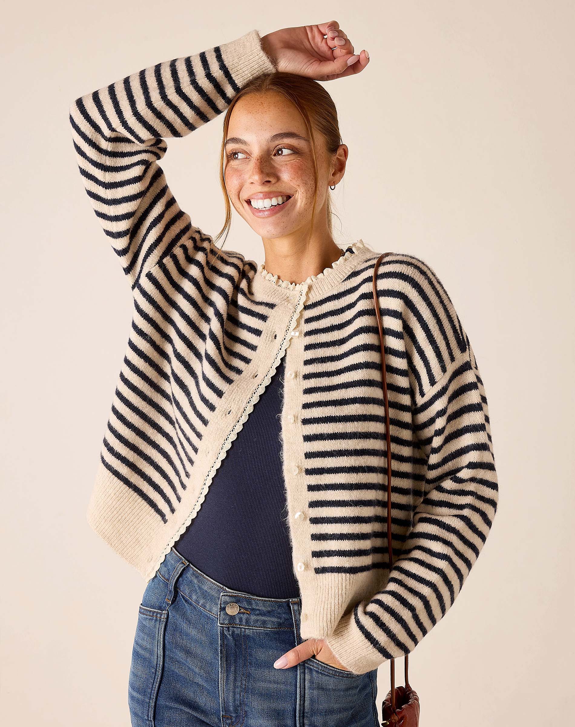 Cream and navy horizontal stripe knit cardigan with a scalloped edge.
