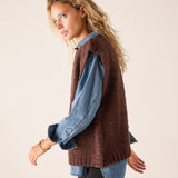 Chocolate brown ribbed knit sweater vest layered over a denim button-down shirt.