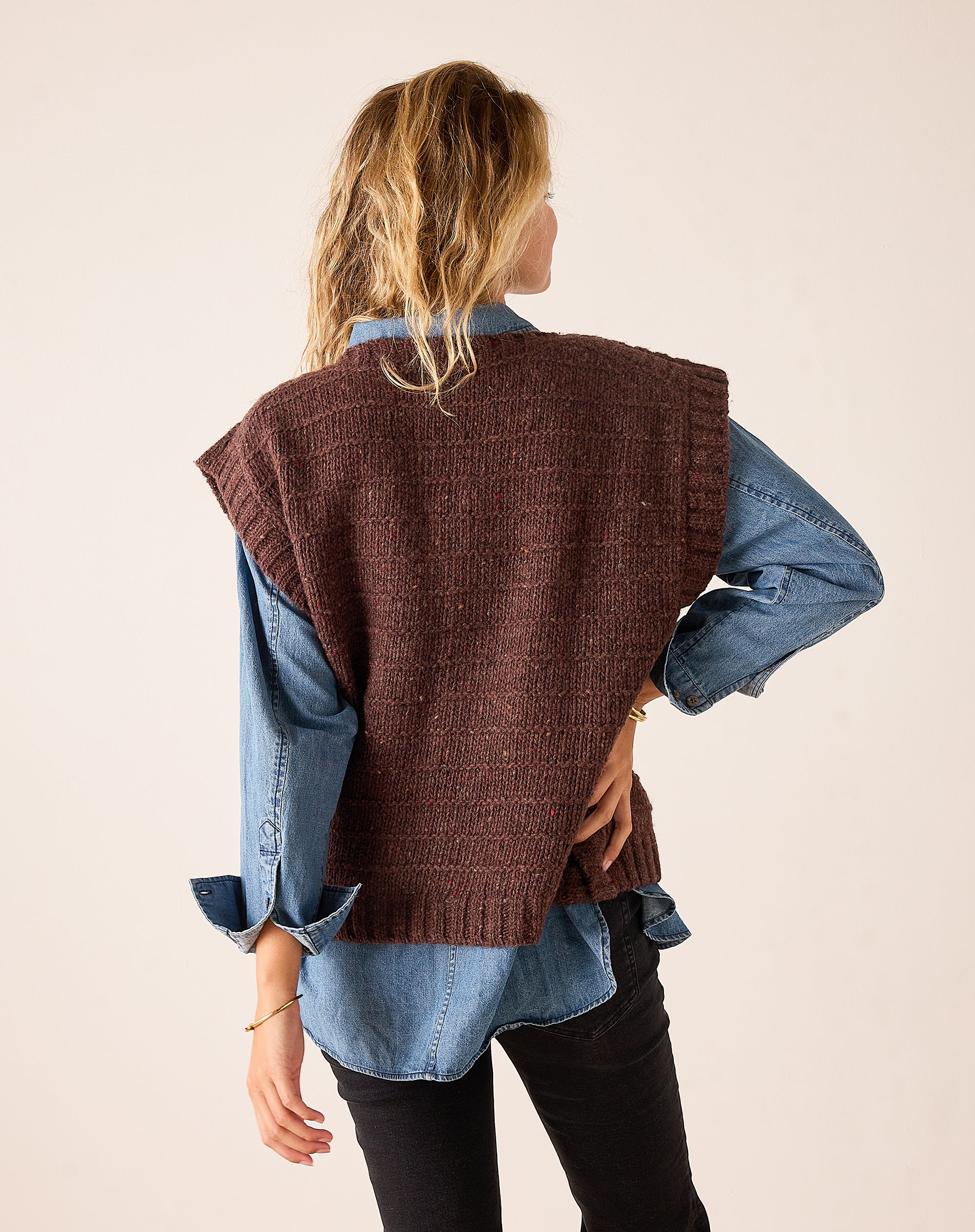 Chocolate brown knit sweater vest with a relaxed fit and a textured weave, shown from the back view.