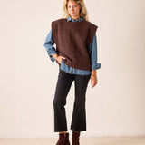 Chocolate brown knit sweater vest with a textured weave worn over a blue denim shirt.