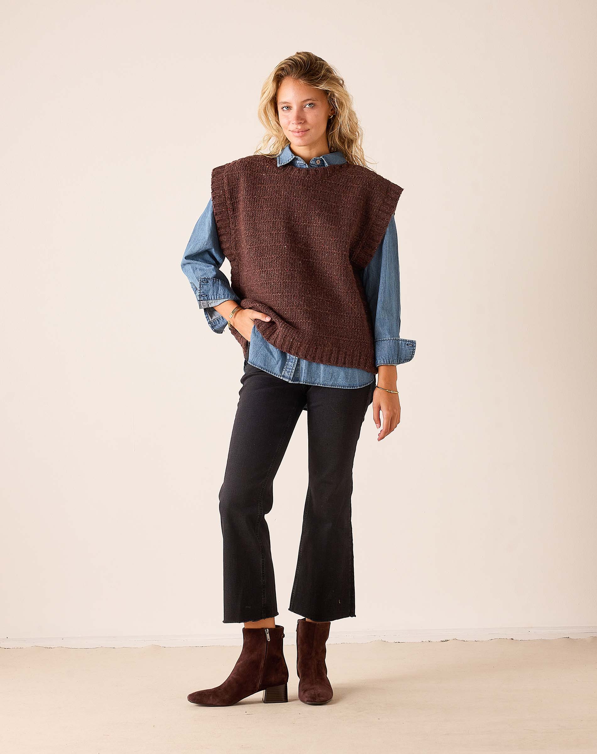Chocolate brown knit sweater vest with a textured weave worn over a blue denim shirt.