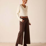 Creme ribbed knit long sleeve polo with button details.