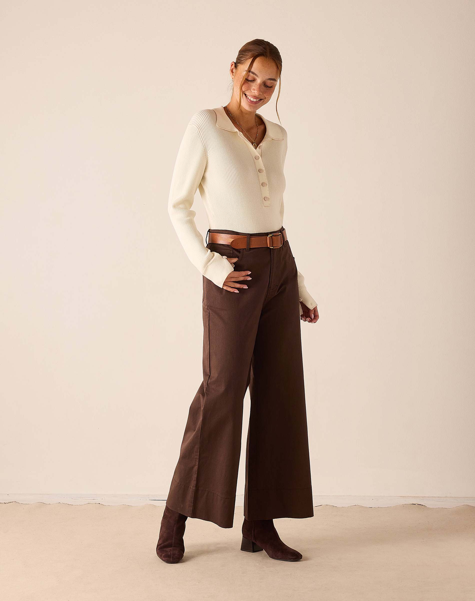 Creme ribbed knit long sleeve polo with button details.