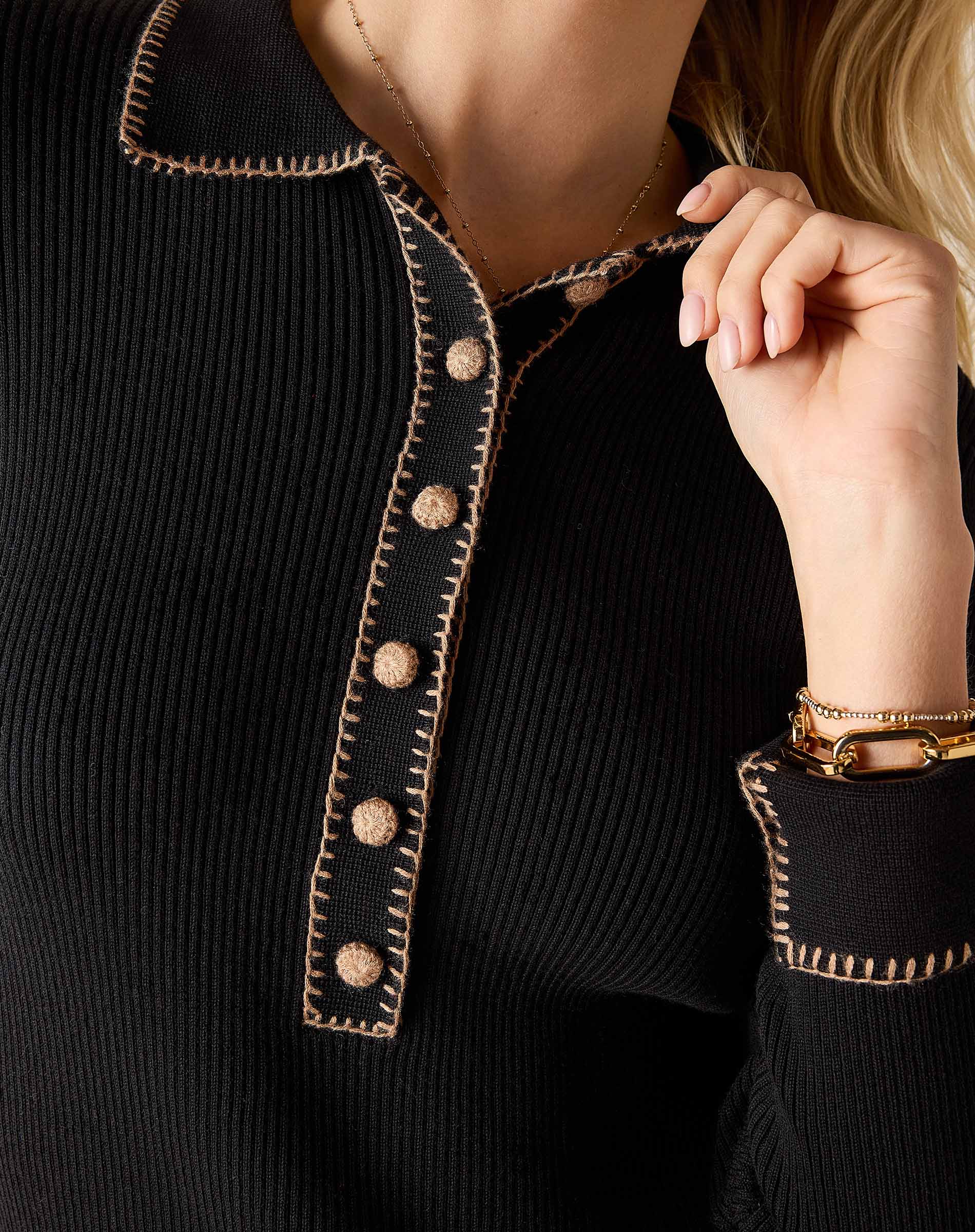 Ink black ribbed knit long sleeve polo with decorative contrast stitching and buttons.