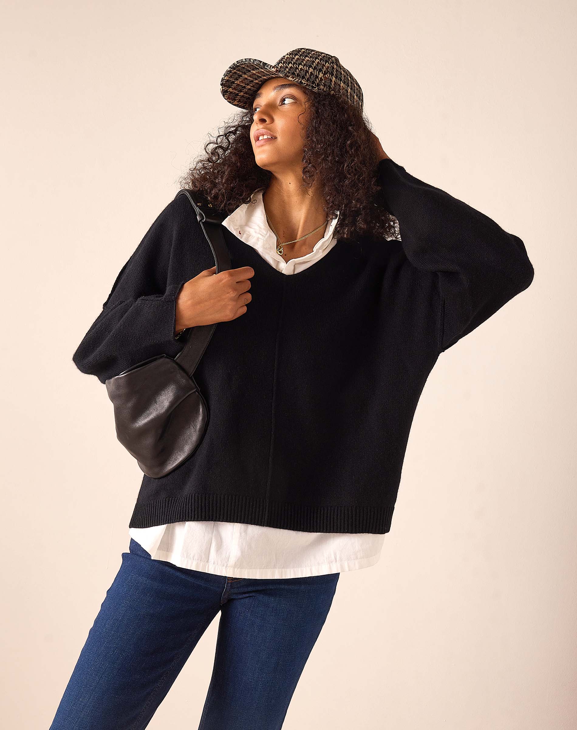 Women's travel-friendly black cashmere v-neck oversized sweater with a wide ribbed hem and drop shoulders.