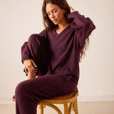 Women's travel-friendly plum v-neck knit cashmere sweater and matching trousers.