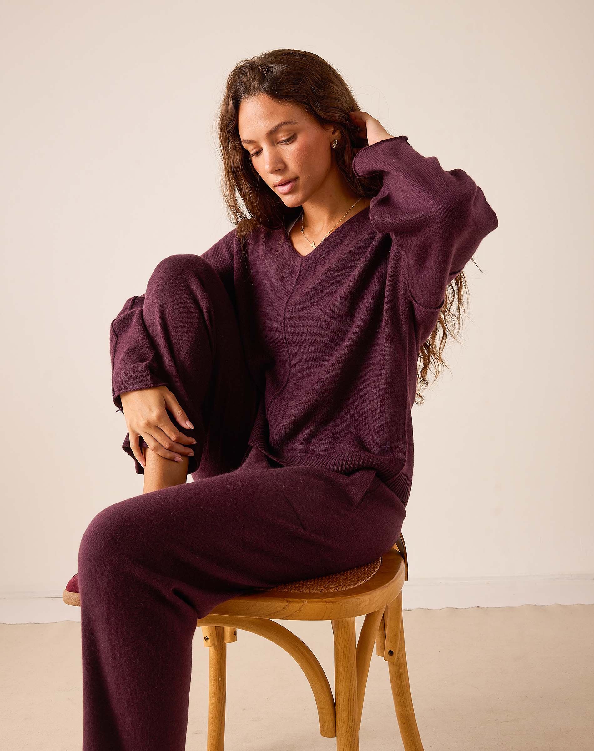 Women's travel-friendly plum v-neck knit cashmere sweater and matching trousers.