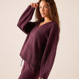 Plum cashmere V-neck knit sweater with drop shoulders and ribbed hem.
