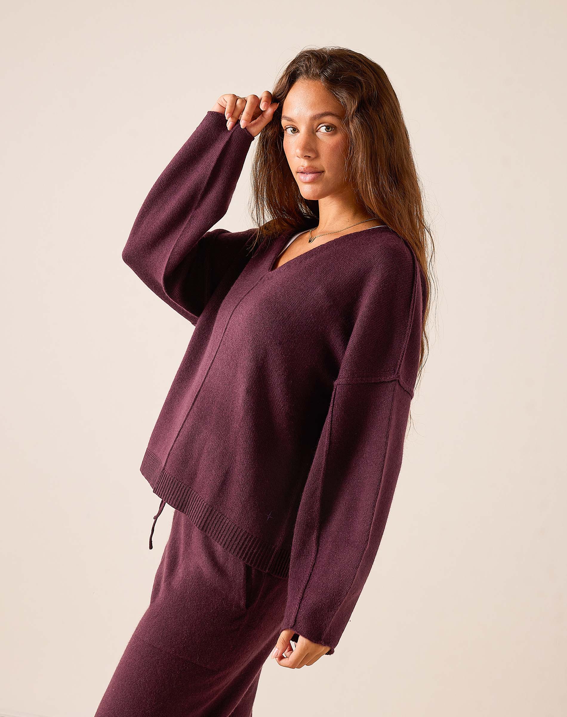 Plum cashmere V-neck knit sweater with drop shoulders and ribbed hem.