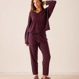 Plum v-neck knit cashmere sweater with long sleeves and a matching knit jogger set.