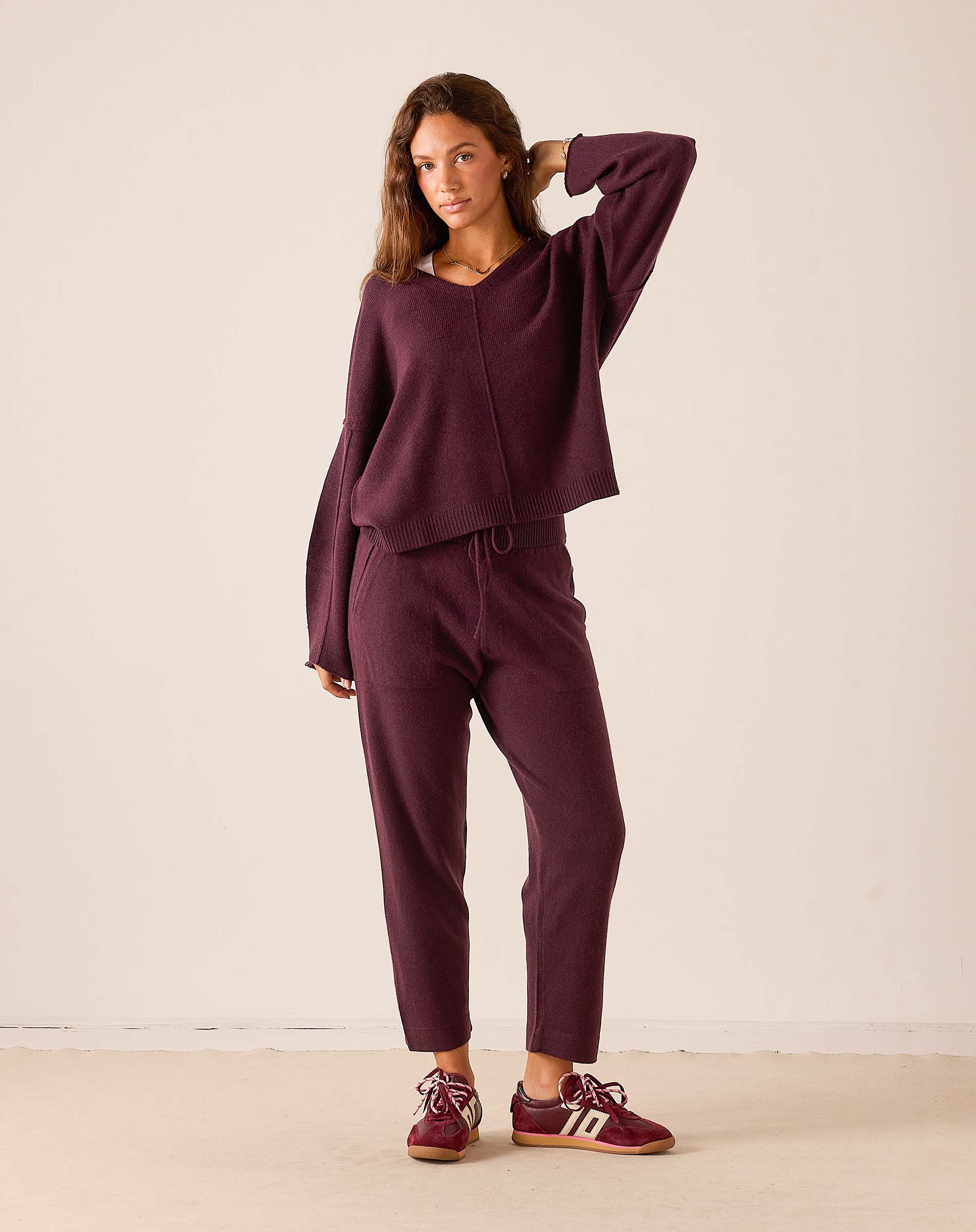 Plum v-neck knit cashmere sweater with long sleeves and a matching knit jogger set.