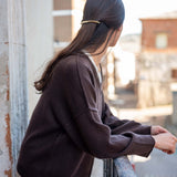 Truffle colored knit v-neck sweater with dropped shoulders and wide ribbed cuffs.