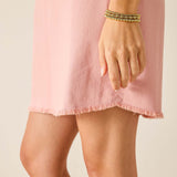 Pink dress with frayed hem on a neutral background