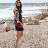 MERSEA ladies' travel-ready midnight blue dress with a tan and white knit shrug over it.