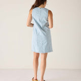 Back view of the light blue twill dress with a sleeveless design and raw hem.