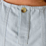 Light blue denim pocket with a button on a person's clothing