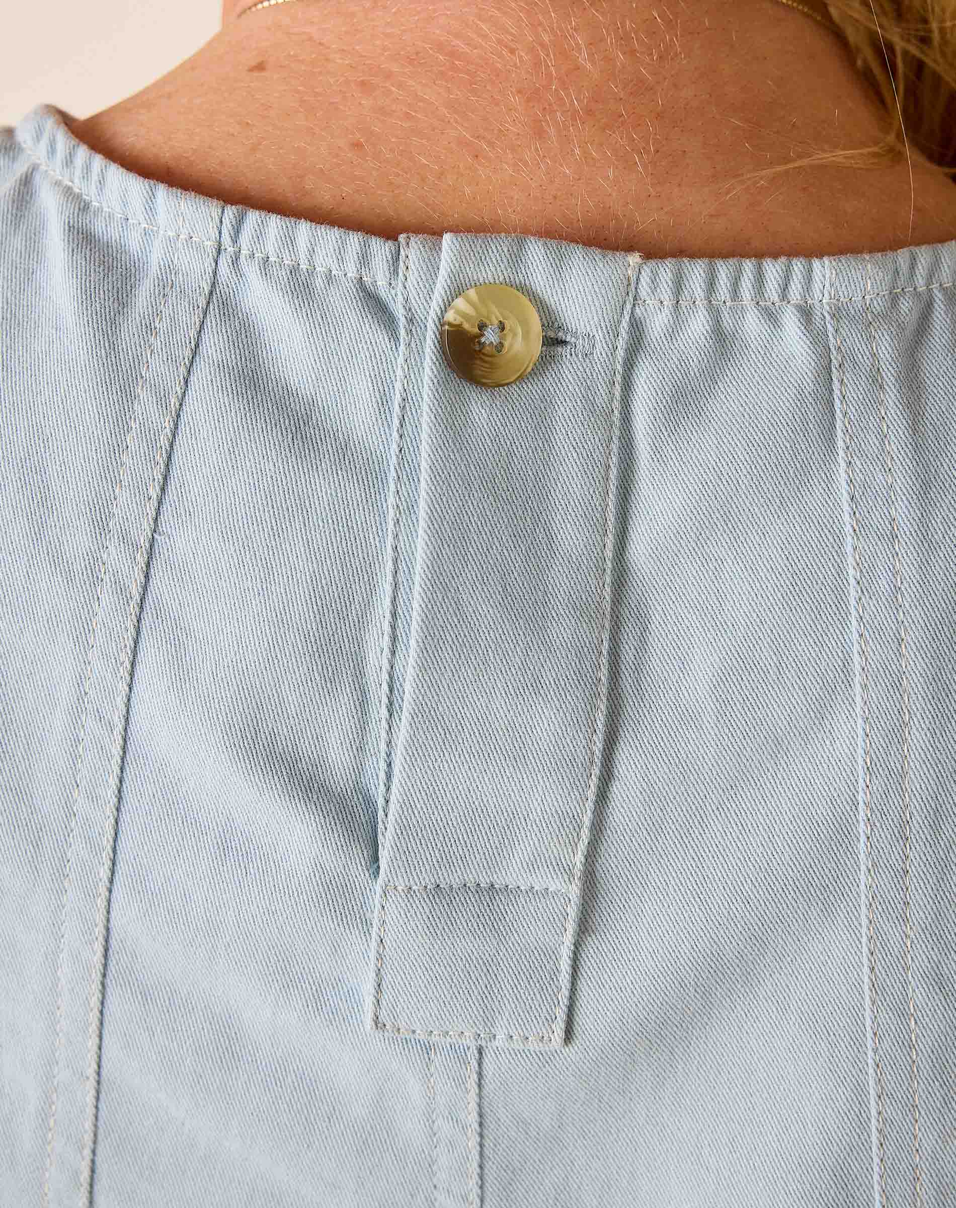 Light blue denim pocket with a button on a person's clothing