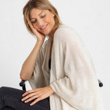 woman wearing mersea luxy wrap in cream with head leaning into hand