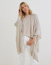 woman wearing mersea cashmere luxy wrap in neutral turtledove color draped over shoulders