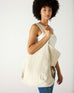 profile of woman with mersea oversized canvas tote in neutral flax over shoulder