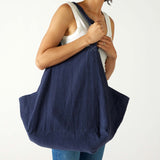 woman with mersea oversized canvas tote in navy blue over right shoulder