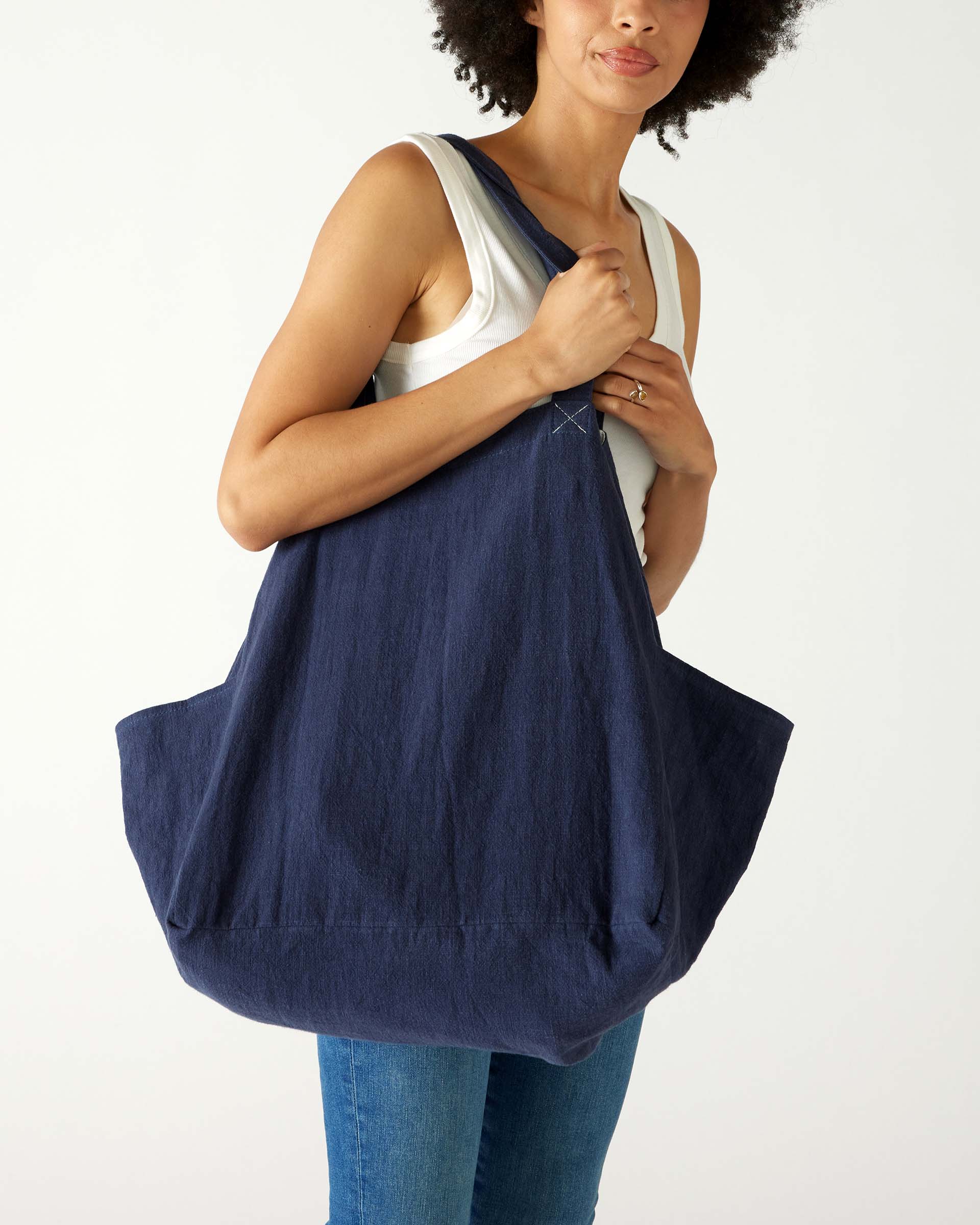 woman with mersea oversized canvas tote in navy blue over right shoulder