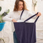 woman with mersea oversized canvas tote in navy blue looking inside tote