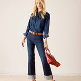 Women's travel-friendly dark indigo denim button-up shirt and matching high-waisted wide-leg jeans with rolled cuffs.