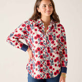 Woman wearing a floral patterned shirt with red flowers on a white background