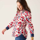 Woman wearing a floral blouse with red flowers on a white background