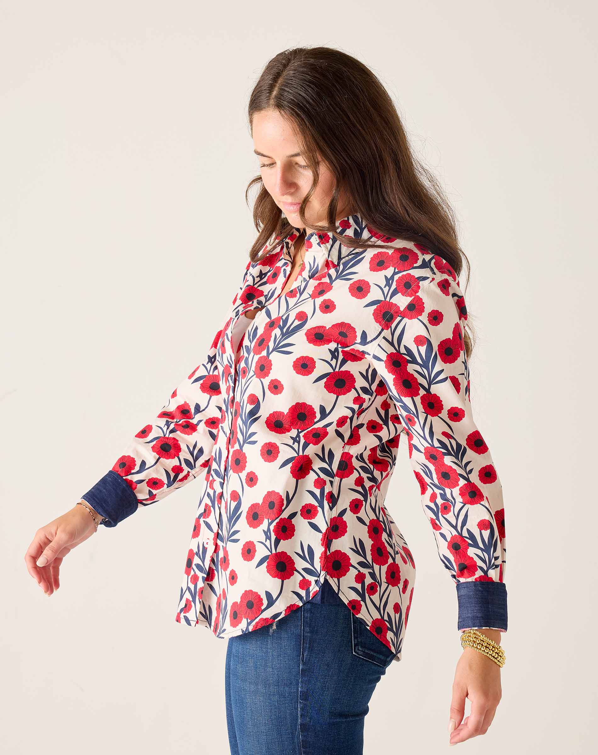 Woman wearing a floral blouse with red flowers on a white background