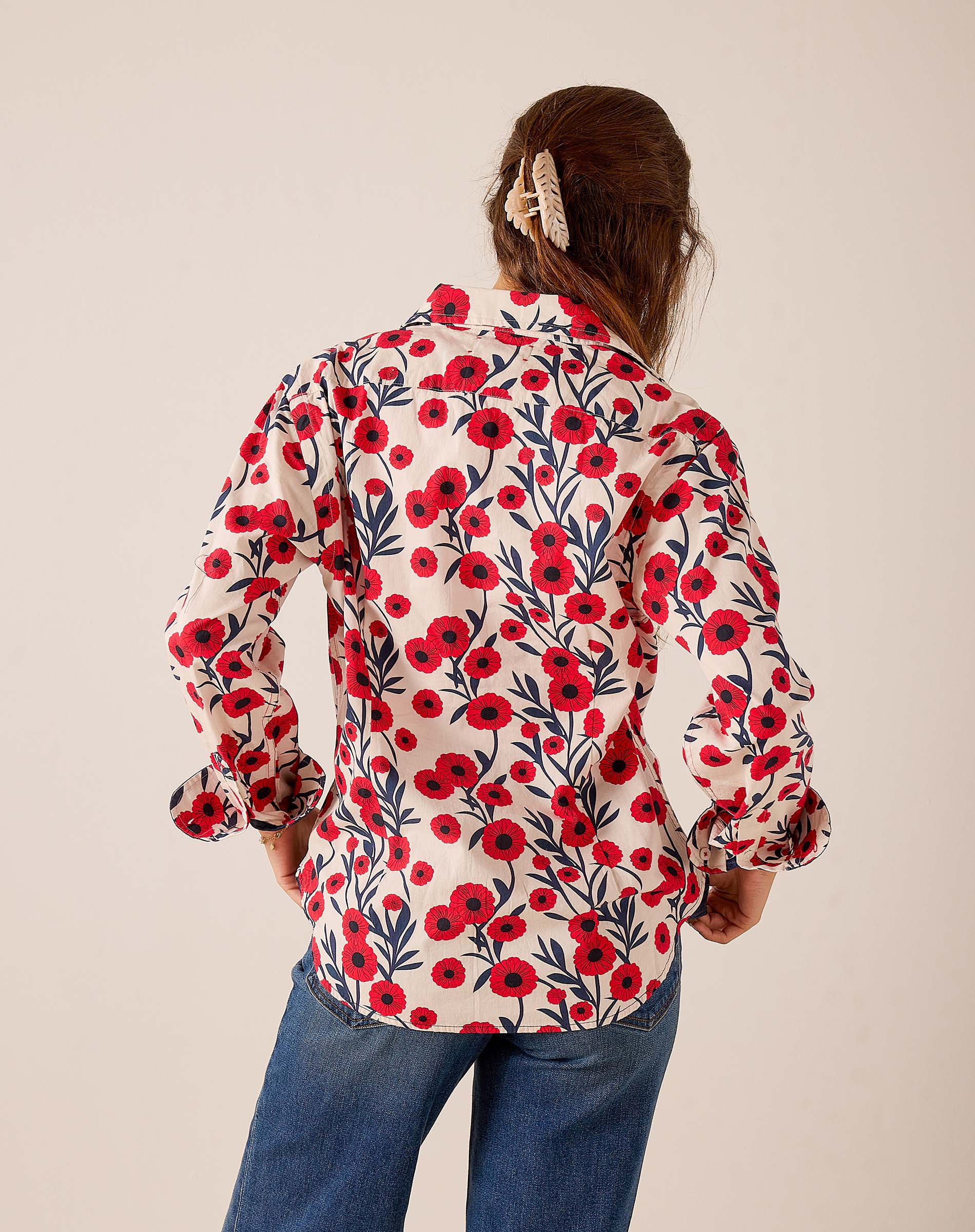 Red and navy poppy floral print button-up shirt with puff sleeves and elastic cuffs, back view.