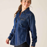 Woman wearing a blue denim shirt against a plain background