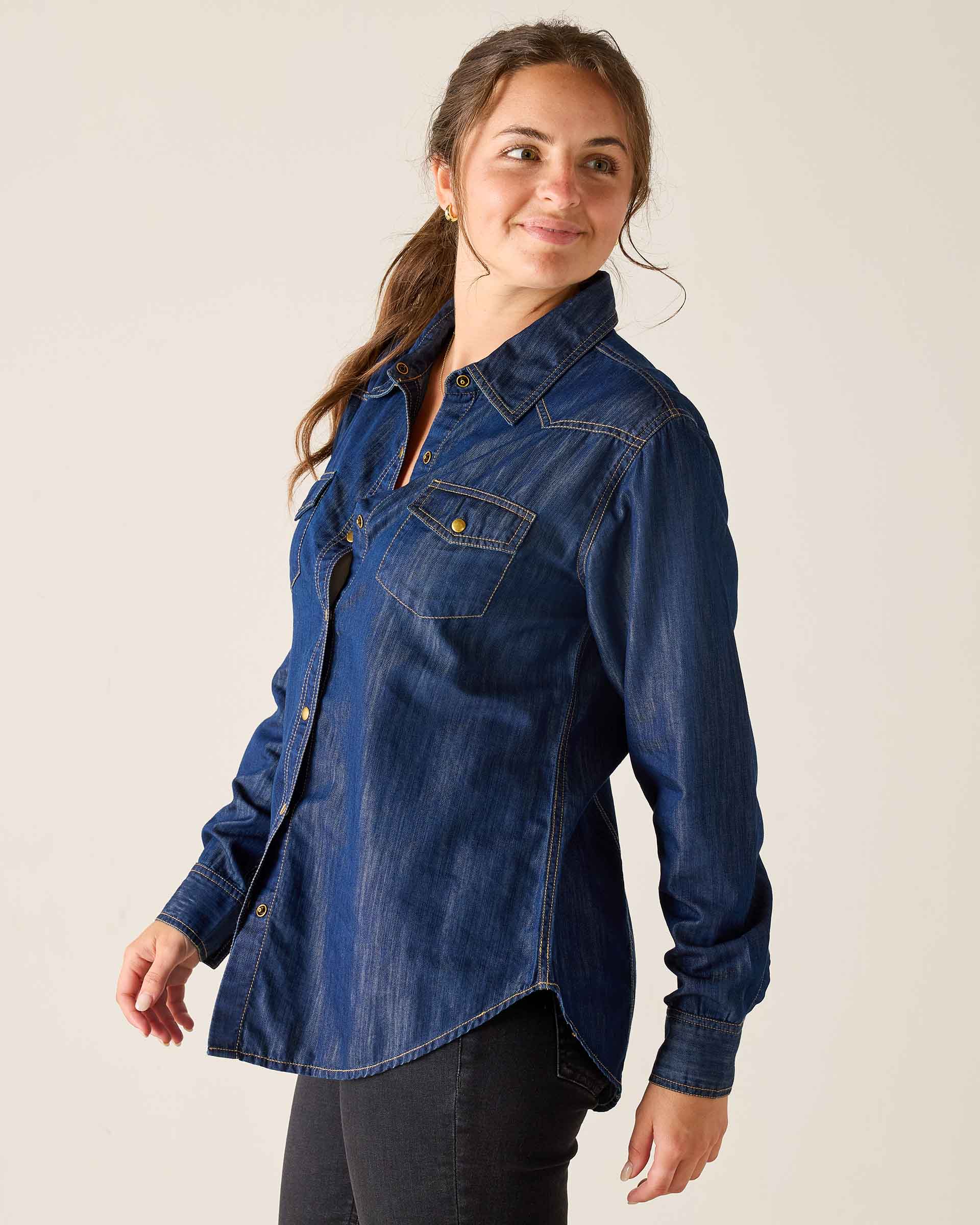 Woman wearing a blue denim shirt against a plain background
